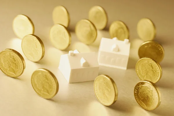 Casas e moedas em miniatura — Fotografia de Stock