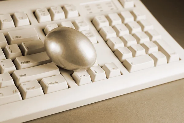 Goldenes Ei auf der Tastatur — Stockfoto