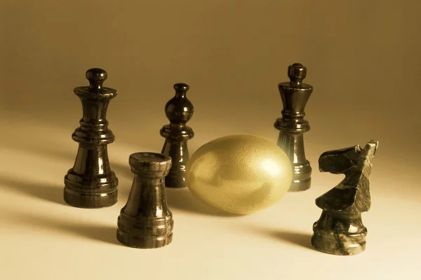 Pedaços de xadrez e ovo dourado — Fotografia de Stock