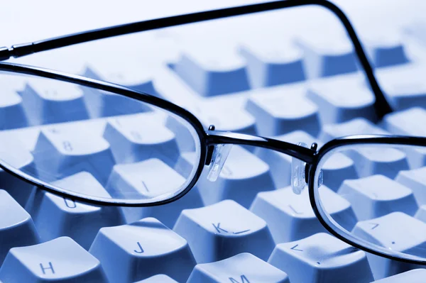 Óculos no teclado — Fotografia de Stock