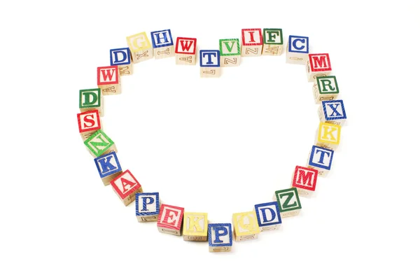 Αλφάβητο μπλοκ που διοργανώνονται σε σχήμα καρδιάς — Φωτογραφία Αρχείου