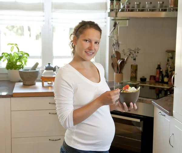 Беременная молодая женщина на кухне — стоковое фото