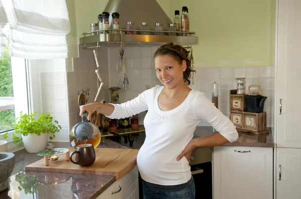 Těhotné mladá žena v kuchyni — Stock fotografie