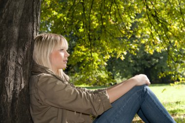 Parkta oturan genç kadın.