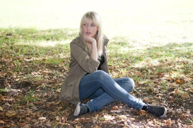 Young woman sitting on a meadow clipart