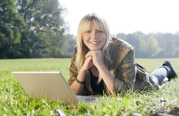 Młoda kobieta z laptopa na łące — Zdjęcie stockowe