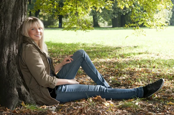 Молодая женщина сидит в парке — стоковое фото