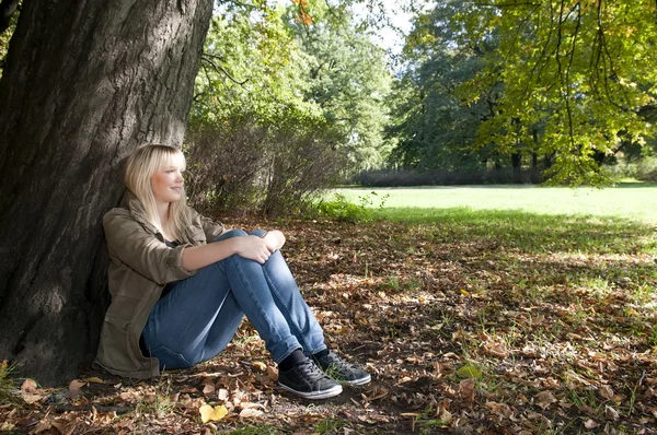 公園に座っている若い女性は — ストック写真