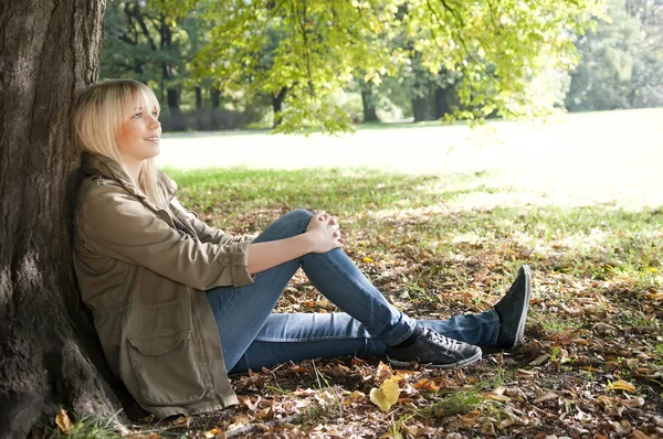 Parkta oturan genç kadın. — Stok fotoğraf