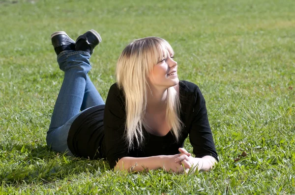 Young woman lying on a meadow — Stock Photo, Image
