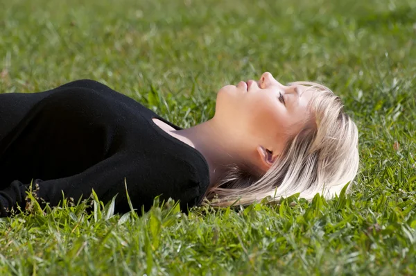 Mladá žena leží na louce — Stock fotografie