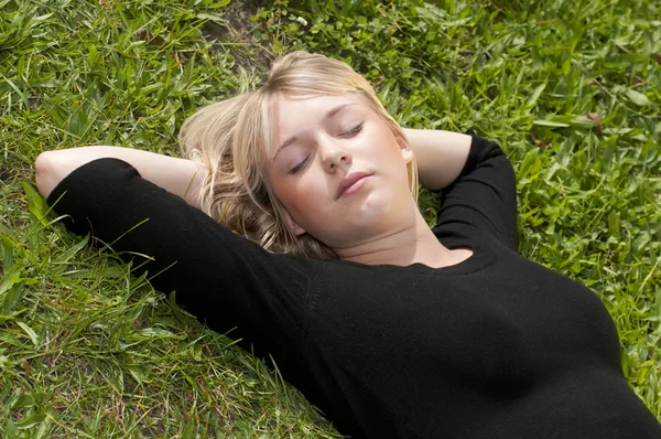 Mujer joven acostada en un prado — Foto de Stock