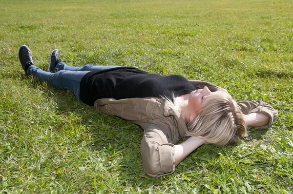 Молодая женщина лежит на лугу — стоковое фото