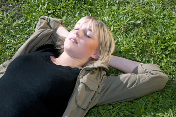 Jeune femme couchée sur une prairie — Photo