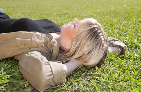 Młoda kobieta, leżąc na łące — Zdjęcie stockowe