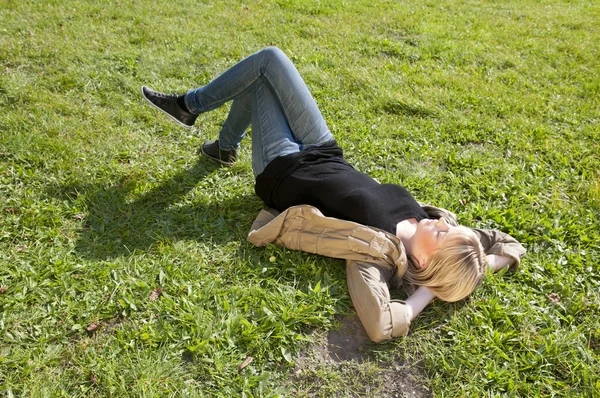 Mujer joven acostada en un prado — Foto de Stock