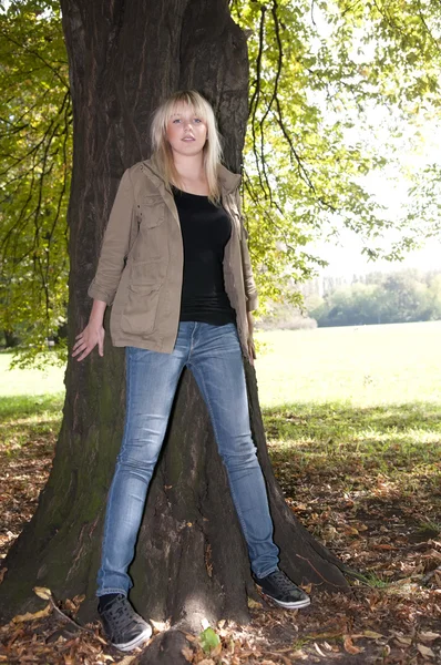 Молодая женщина стоит на дереве — стоковое фото