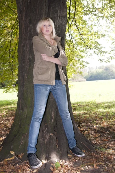 Young woman stands on a tree — Stock Photo, Image