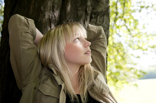 年轻女人站在一棵树上 — 图库照片