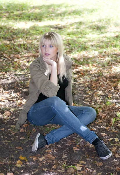 年轻女子坐在一片草地上 — 图库照片