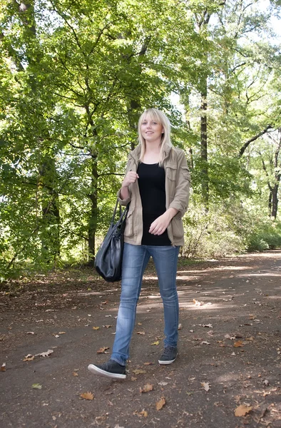 Mladá žena procházky v parku — Stock fotografie