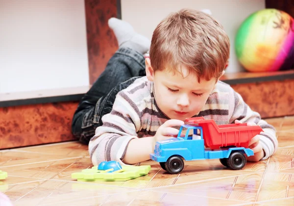 Küçük çocuk oyuncak arabayla oynuyor. Stok Resim