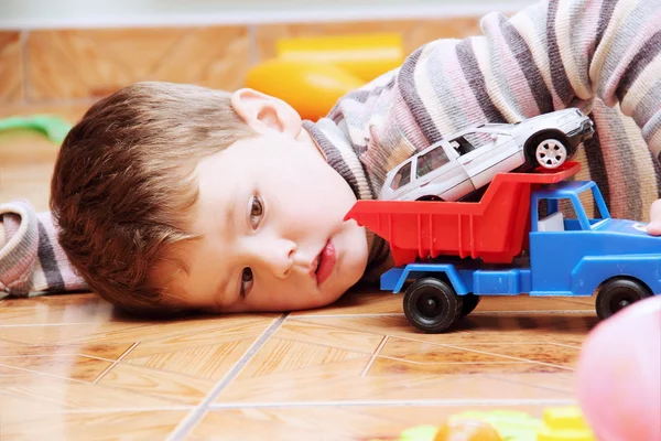 おもちゃの車で遊んで小さな男の子を閉じる — ストック写真