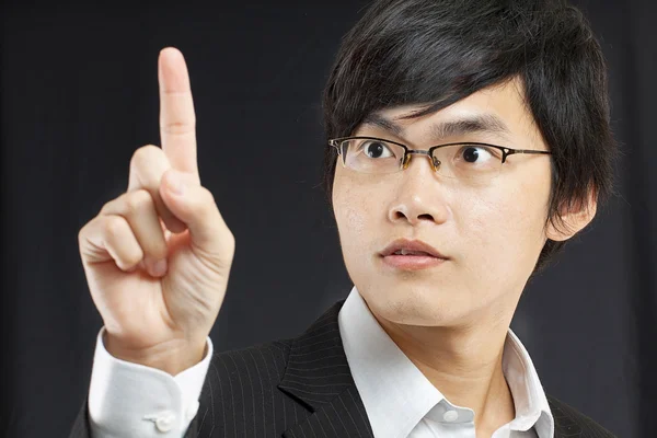 Joven hombre de negocios con un traje señalando con el dedo — Foto de Stock