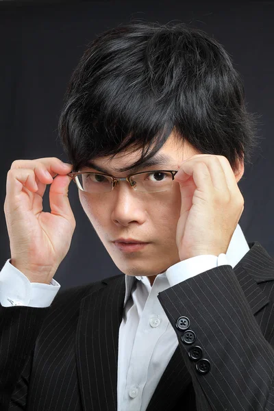 Closeup portrait of a asian young man wearing spectacles against — Stock Photo, Image