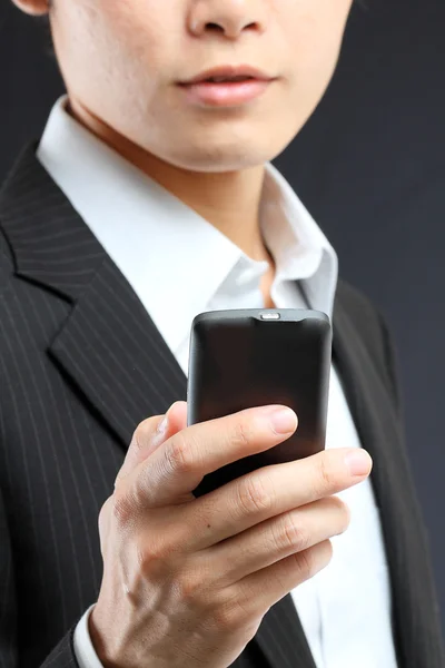 Homem de negócios em terno preto trabalhando no pda ou smartphone — Fotografia de Stock