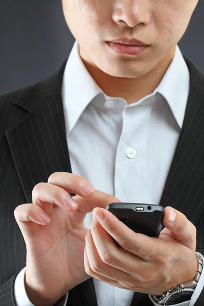 Homem de negócios em terno preto trabalhando no pda ou smartphone — Fotografia de Stock