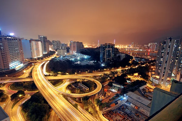 Autobahn in der Nacht mit beleuchteten Autos in der modernen Stadt. — Stockfoto