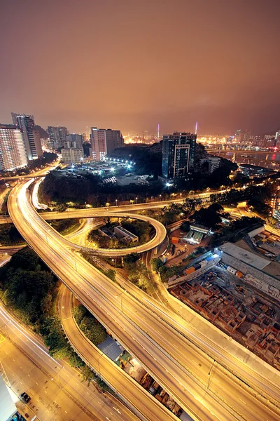 Autostrada w nocy z samochodów światła w nowoczesne miasto. — Zdjęcie stockowe