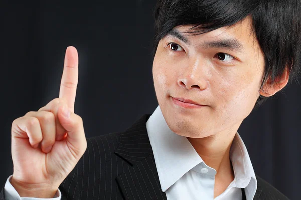 Jovem homem de negócios em um terno apontando com o dedo — Fotografia de Stock