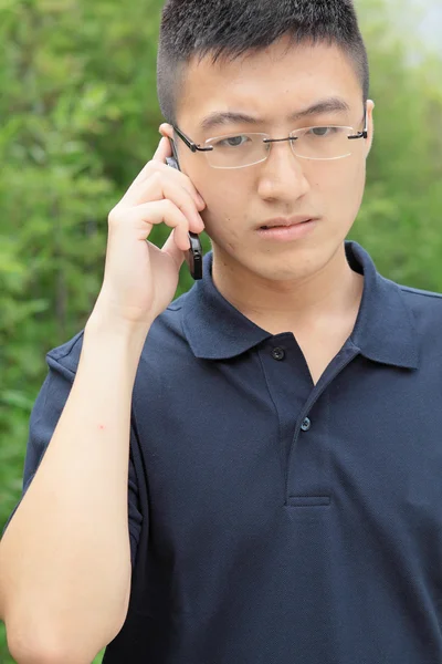 Китаец говорит по телефону и беспокоиться — стоковое фото