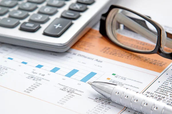 Aktiendiagramm mit Taschenrechner, Stift und Brille — Stockfoto