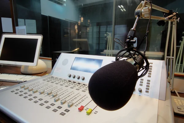Микрофон перед панелью управления в студии вещания — стоковое фото