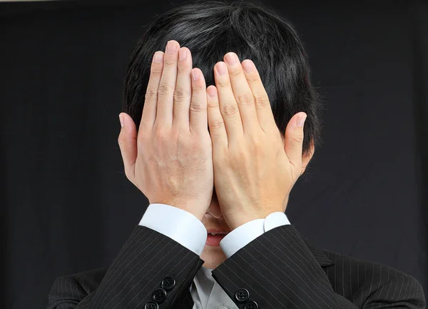 Empresário cobrindo seu rosto por mãos — Fotografia de Stock