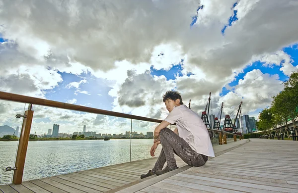アジア人の男性が公園で座っています。 — ストック写真