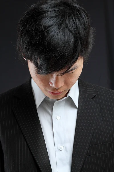 Jovem asiático homem olhando para baixo — Fotografia de Stock