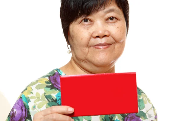 Mujer asiática sosteniendo una tarjeta roja — Foto de Stock