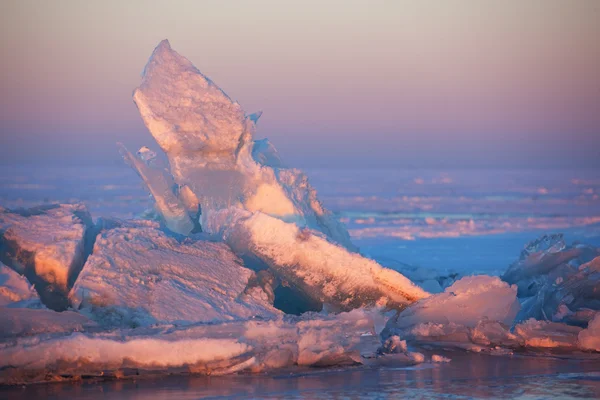 Зимовий захід сонця та льодові горбки на озері — стокове фото