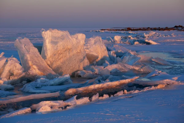 Tramonto invernale e hummocks ghiaccio sul lago Foto Stock Royalty Free
