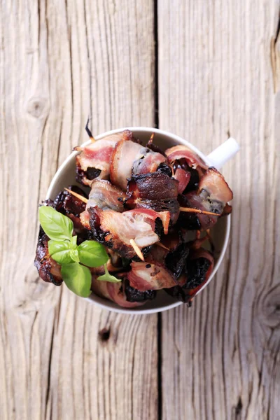 Ameixas secas embrulhadas em bacon — Fotografia de Stock