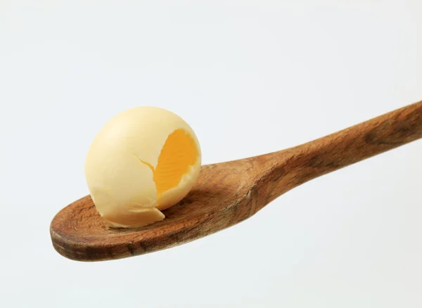 Máslo oblouček na dřevěnou lžící — Stock fotografie