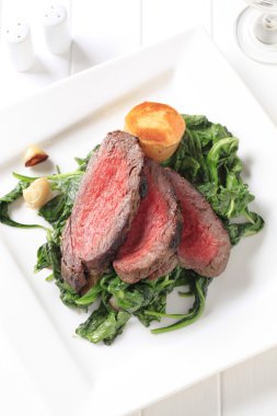 Roast beef and sauteed spinach clipart