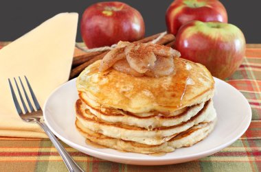 Stacked pancakes with baked apples topping. clipart