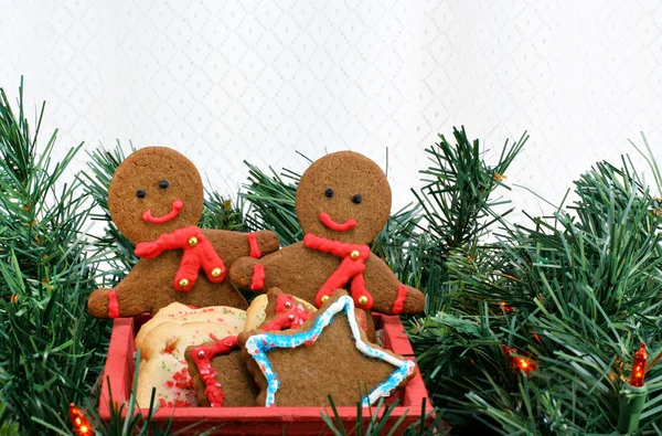 Due uomini di pan di zenzero nel carrello tra i verdi di Natale con spazio copia . — Foto Stock