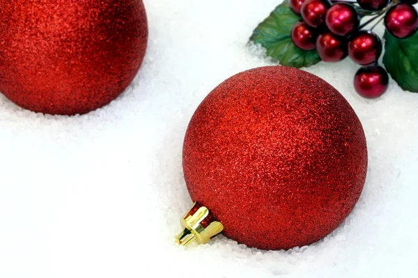 Red sparkle christmas ornamenten in de sneeuw — Stockfoto