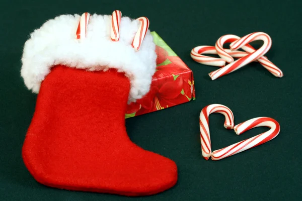 Julstrumpa med polkagrisar och gåva. — Stockfoto